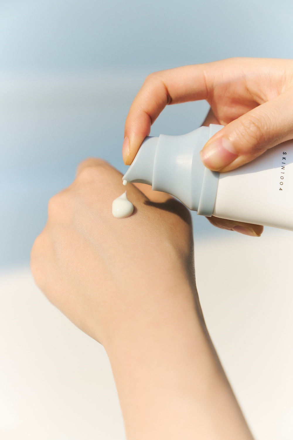 Sun serum bottle held for size reference