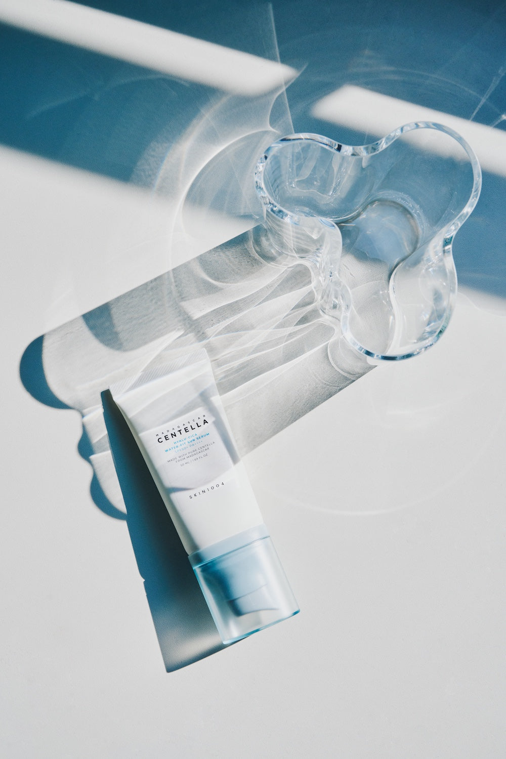Sun serum bottle next to a folded towel