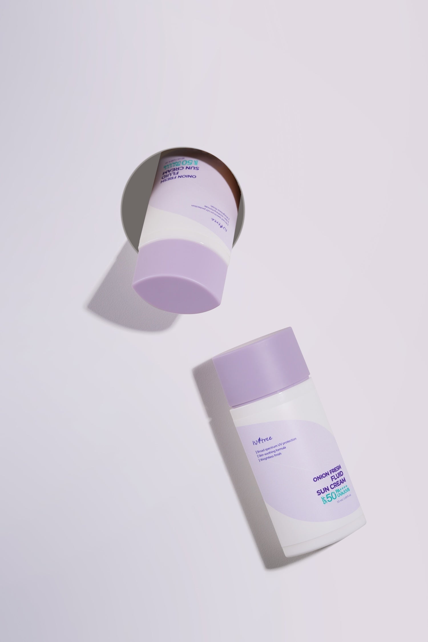 Isntree sun cream bottle held up to natural light