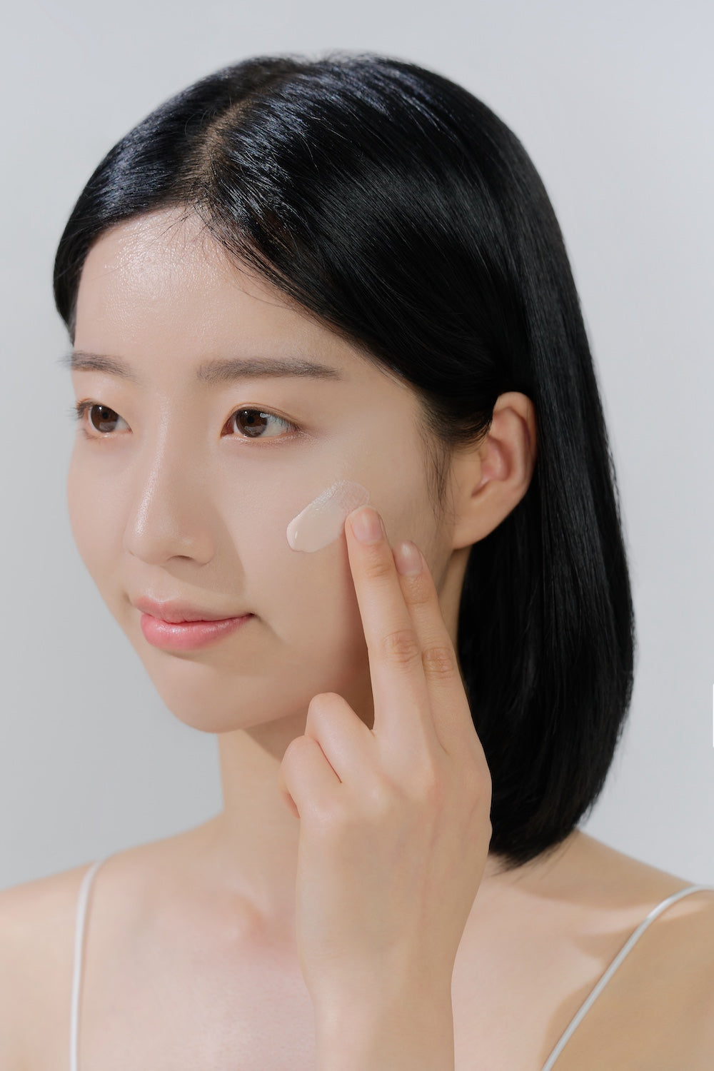 SKIN1004 Tone-Up Sunscreen bottle held at an angle to show the label