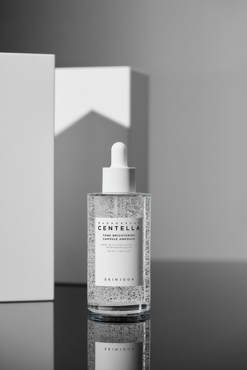 Tone brightening ampoule next to toner bottle