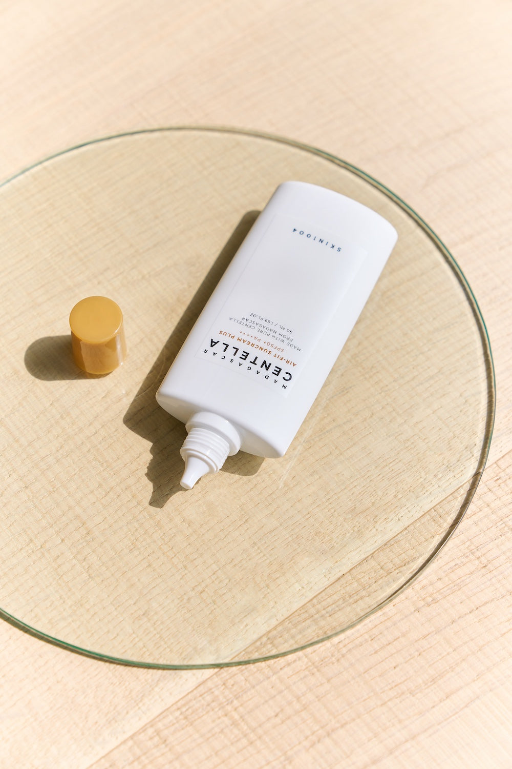 Suncream bottle next to sun serum for comparison
