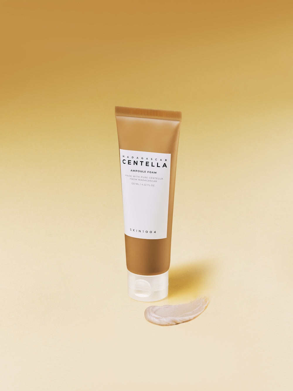 The tube's nozzle shown dispensing a small amount of product