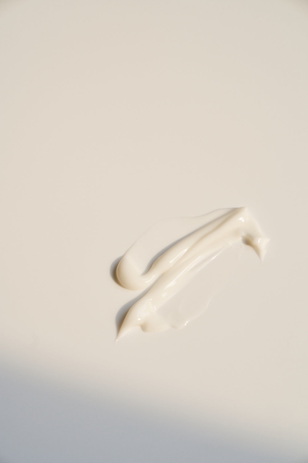 Close-up of cream texture stretched between fingers